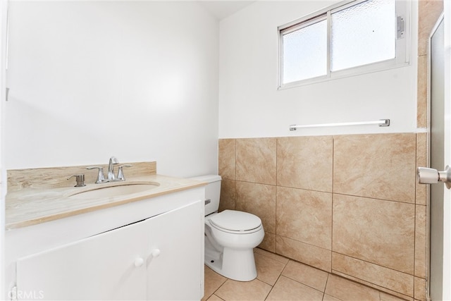 bathroom featuring tile patterned flooring, tile walls, toilet, and vanity