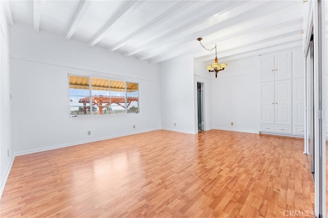 unfurnished room with beam ceiling, a notable chandelier, baseboards, and light wood finished floors