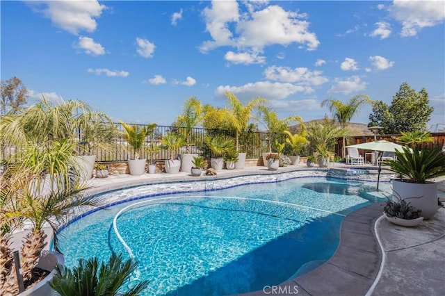 view of swimming pool with a patio, a fenced backyard, and a pool with connected hot tub