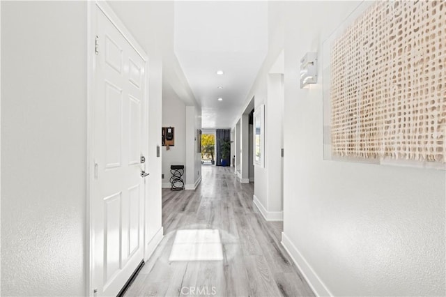 hall featuring recessed lighting, baseboards, and light wood finished floors