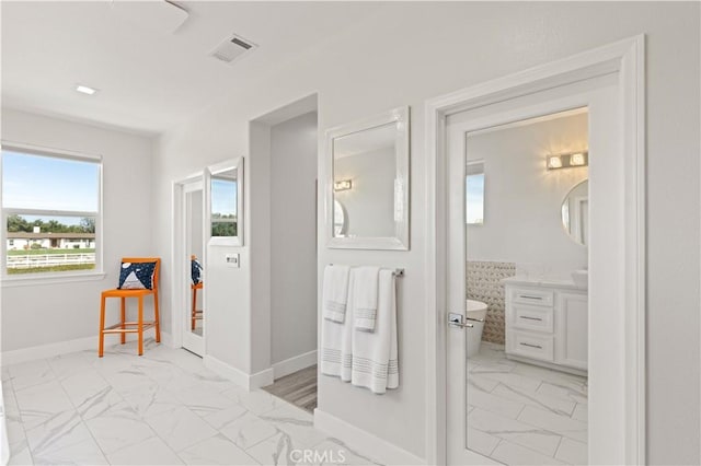 bathroom featuring visible vents, marble finish floor, vanity, and baseboards