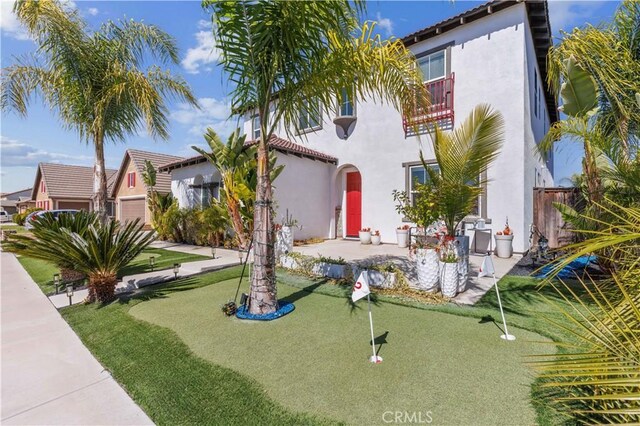 exterior space with a tiled roof, a balcony, and stucco siding