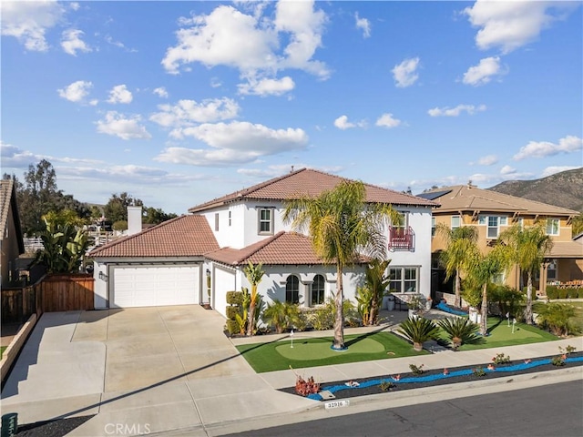 mediterranean / spanish house featuring stucco siding, a garage, driveway, and a tiled roof