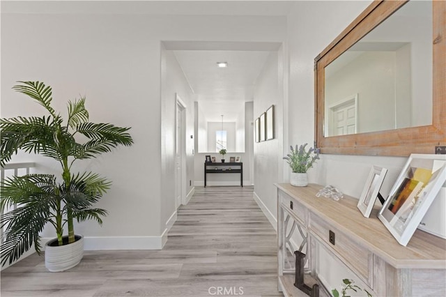 hallway with light wood-style floors and baseboards