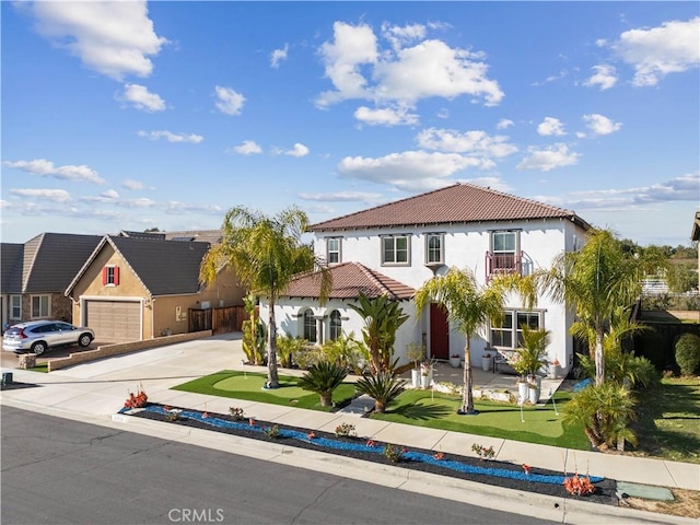 mediterranean / spanish home featuring concrete driveway, a garage, a tile roof, and stucco siding