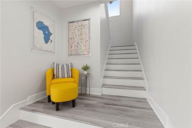 staircase featuring wood finished floors and baseboards