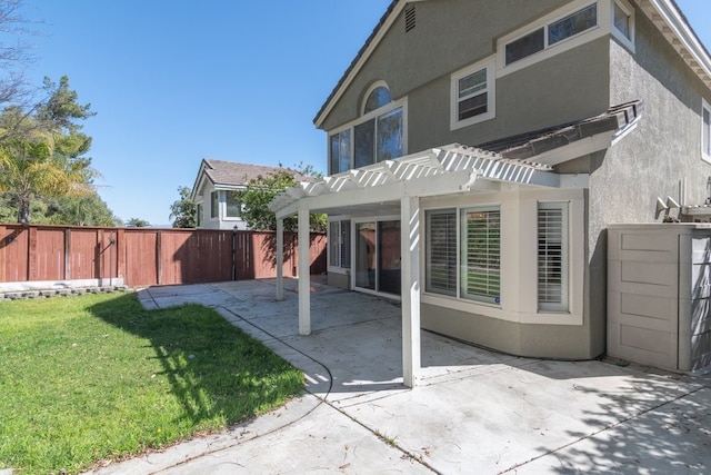 back of house with stucco siding, fence, a pergola, and a patio area