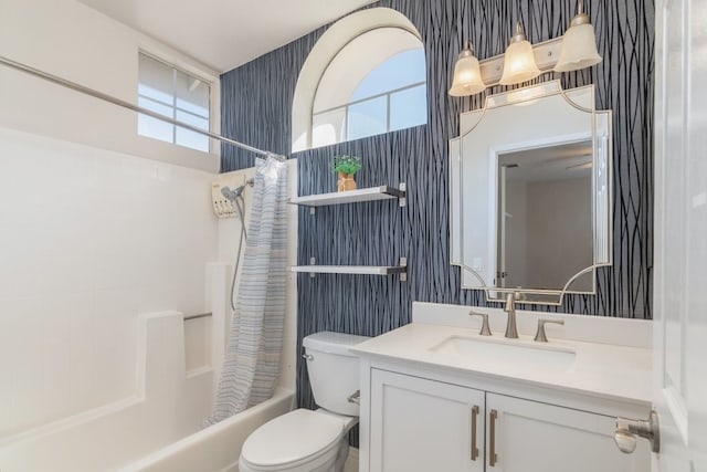 bathroom with wallpapered walls, toilet, vanity, and shower / bath combo with shower curtain