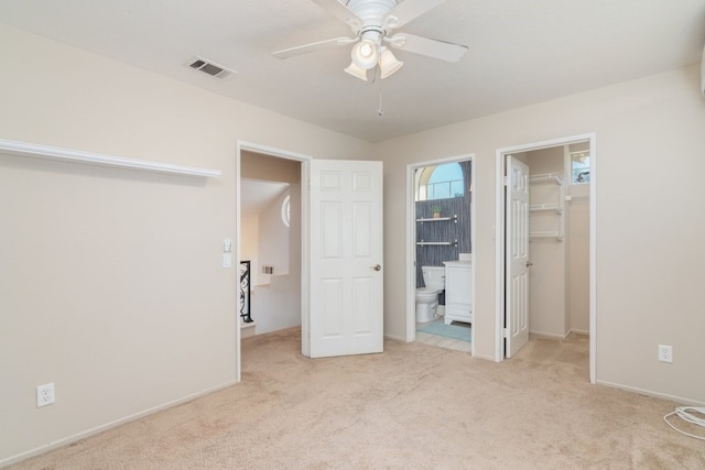 unfurnished bedroom with visible vents, carpet floors, a spacious closet, a closet, and connected bathroom