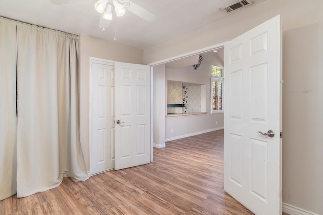 unfurnished bedroom with a ceiling fan, wood finished floors, visible vents, and baseboards