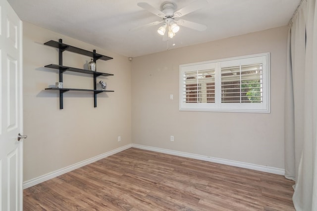 spare room featuring baseboards, a ceiling fan, and wood finished floors