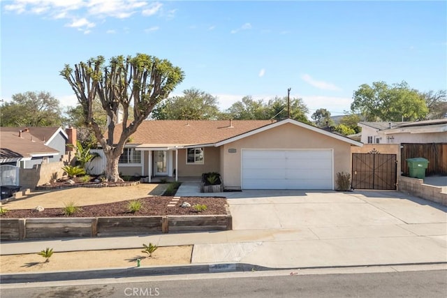 ranch-style home with a gate, fence, an attached garage, stucco siding, and concrete driveway