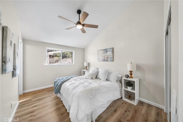 bedroom with baseboards, a ceiling fan, lofted ceiling, and wood finished floors