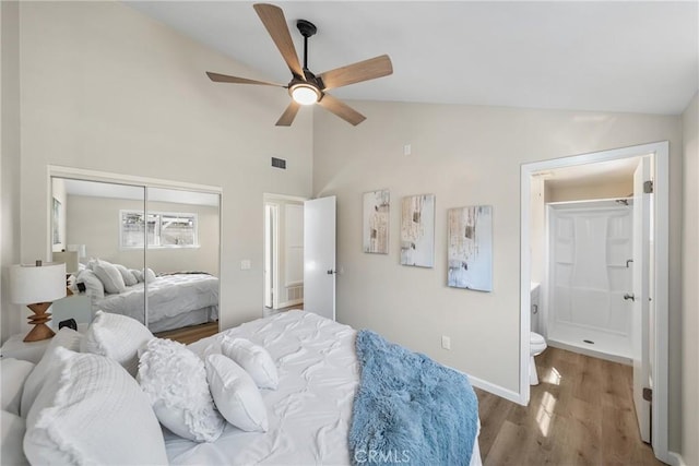 bedroom featuring visible vents, a closet, wood finished floors, and vaulted ceiling