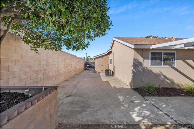 view of property exterior featuring fence, central AC, and stucco siding