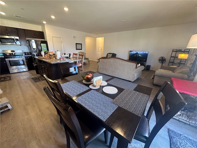 dining space featuring visible vents, recessed lighting, and wood finished floors