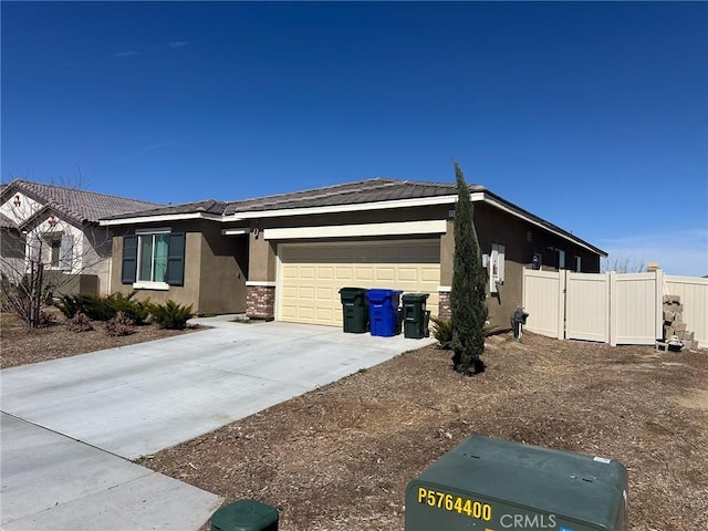 view of front of home featuring concrete driveway, fence, a garage, and stucco siding