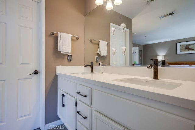 bathroom with double vanity, a sink, and visible vents