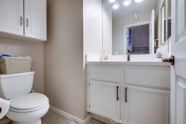 bathroom with toilet, tile patterned floors, vanity, and baseboards