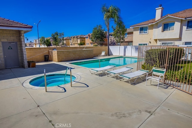 community pool with fence, a residential view, a patio, and a community hot tub