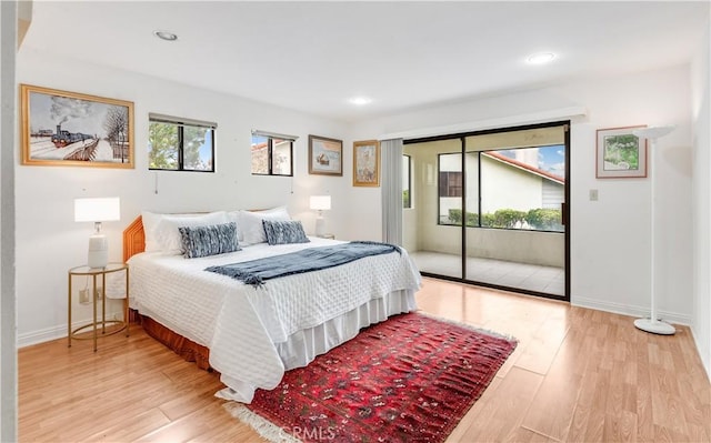 bedroom featuring light wood-type flooring, multiple windows, baseboards, and access to exterior