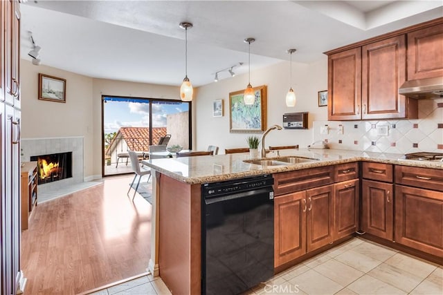 kitchen with light stone counters, a peninsula, a sink, decorative backsplash, and dishwasher