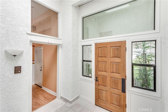 entryway with baseboards and a textured wall