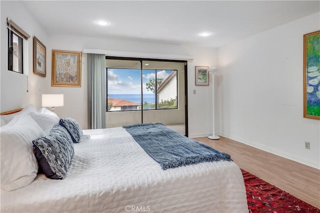 bedroom featuring access to exterior, recessed lighting, wood finished floors, and baseboards