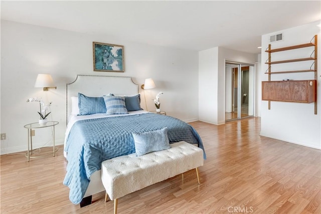 bedroom featuring baseboards, visible vents, and light wood finished floors