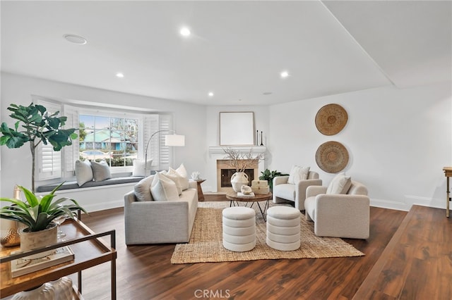 living room with recessed lighting, wood finished floors, baseboards, and a high end fireplace