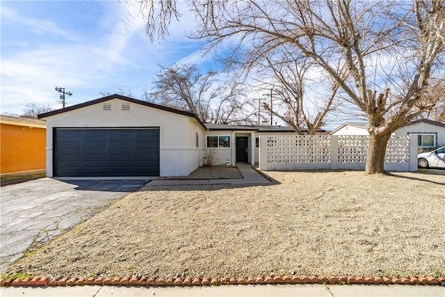 single story home with a garage, aphalt driveway, stucco siding, and fence