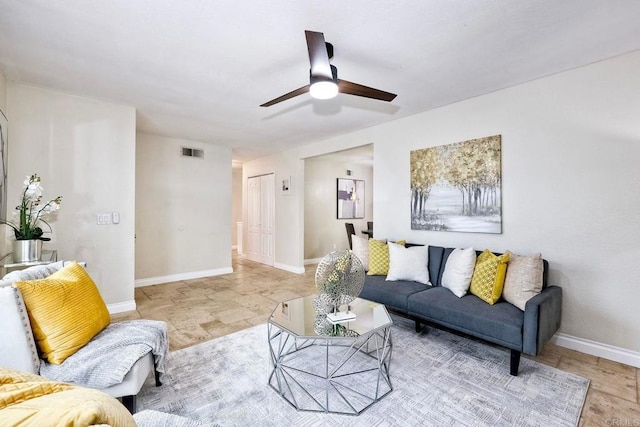 living area with visible vents, baseboards, and a ceiling fan