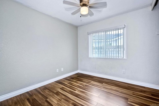 unfurnished room featuring ceiling fan, baseboards, and dark wood-style floors