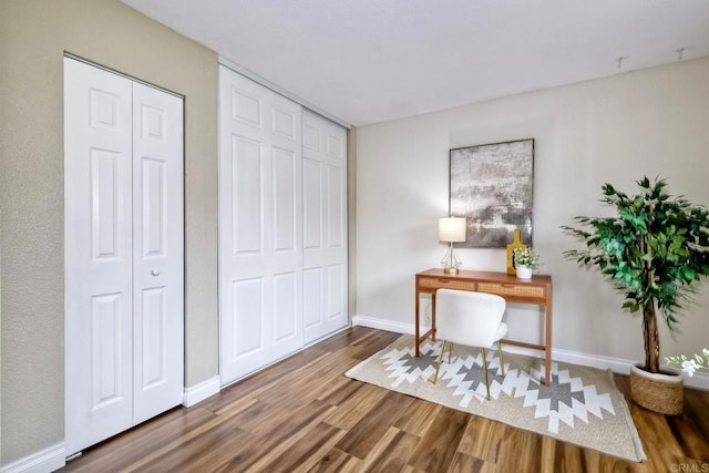 office space featuring baseboards and wood finished floors