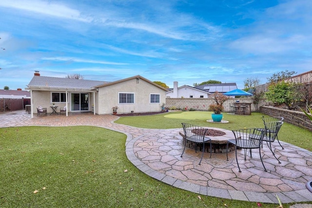 back of house with stucco siding, a patio, a fire pit, and a fenced backyard