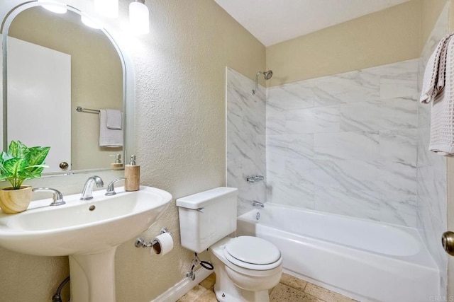 bathroom with toilet, a sink, shower / tub combination, baseboards, and a textured wall