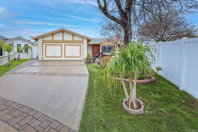 view of front of home with a front yard, fence, and driveway