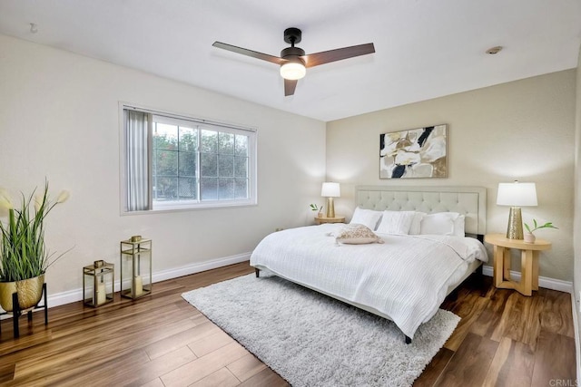 bedroom featuring a ceiling fan, baseboards, and wood finished floors