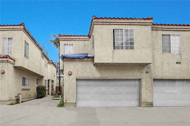 view of front of house with concrete driveway, an attached garage, and stucco siding