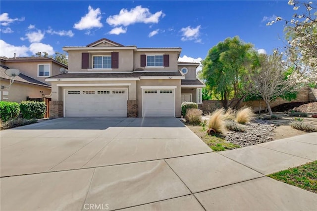 view of front of property featuring a garage, stone siding, driveway, and stucco siding