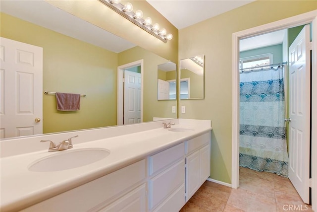 full bath with a sink, baseboards, double vanity, and tile patterned flooring