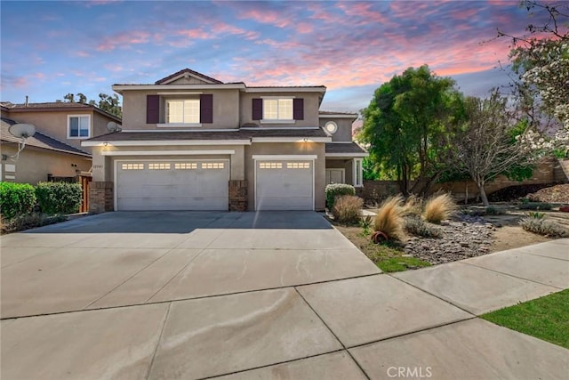 traditional-style home with stucco siding, concrete driveway, and an attached garage