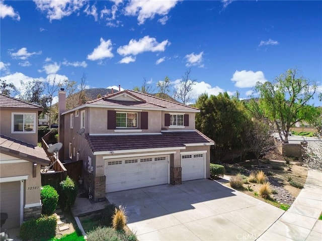 view of front of home with a tiled roof, stucco siding, driveway, stone siding, and an attached garage