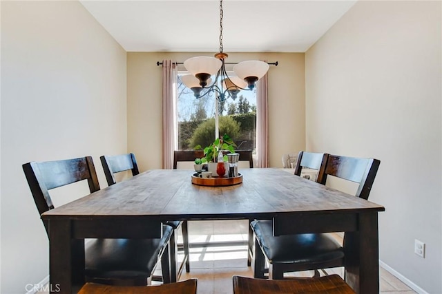 dining area with baseboards and a chandelier