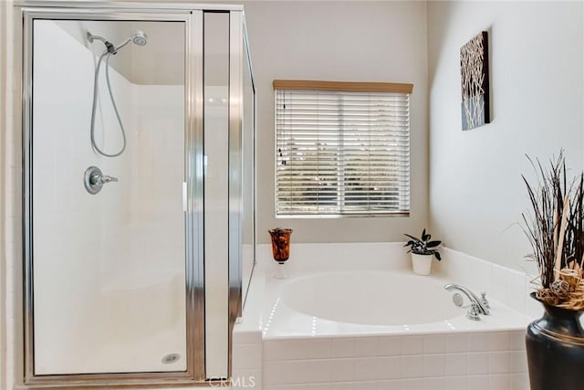 bathroom featuring a bath and a stall shower