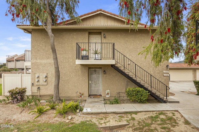view of front of home with stucco siding and stairway