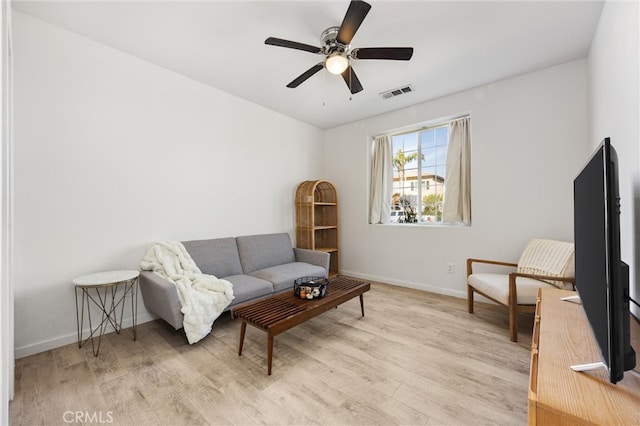 living area with light wood-style flooring, baseboards, visible vents, and ceiling fan