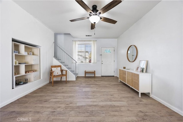 foyer with baseboards, visible vents, light wood finished floors, and ceiling fan