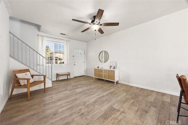 entryway with visible vents, baseboards, ceiling fan, stairs, and wood finished floors