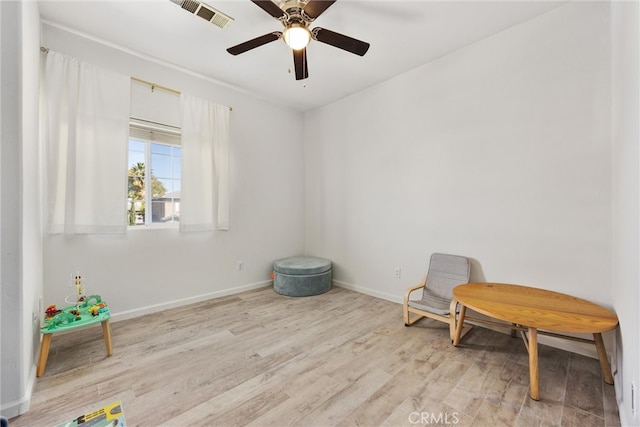 sitting room with visible vents, baseboards, wood finished floors, and a ceiling fan